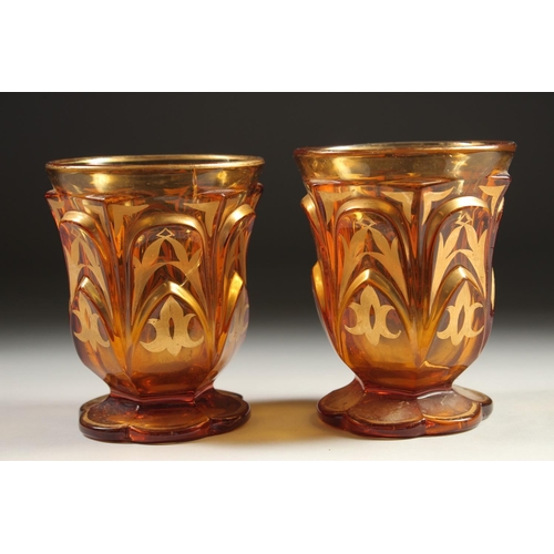 1080 - A PAIR OF AMBER TINTED BEYKOS BEAKERS. 4.75ins