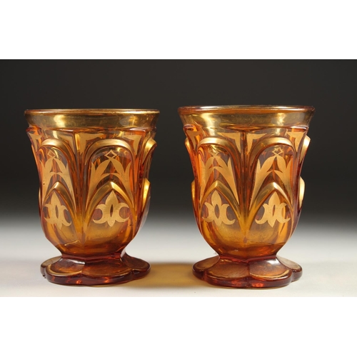 1080 - A PAIR OF AMBER TINTED BEYKOS BEAKERS. 4.75ins