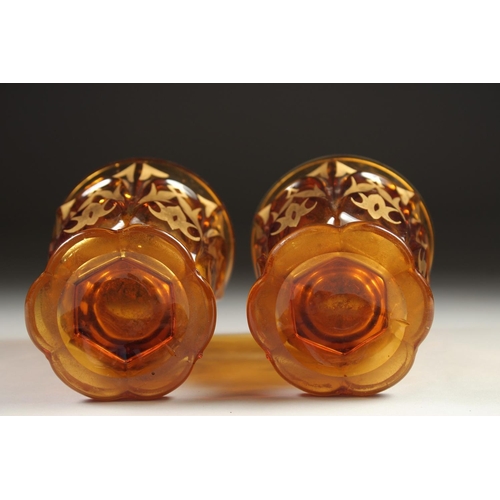 1080 - A PAIR OF AMBER TINTED BEYKOS BEAKERS. 4.75ins