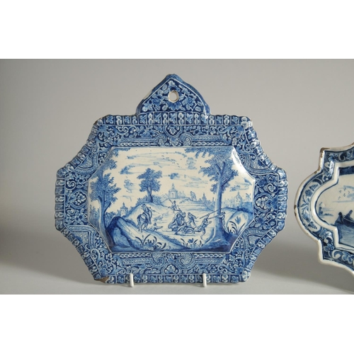 1125 - THREE 19TH CENTURY DUTCH BLUE AND WHITE SHAPED PLAQUES, a horse and rider pulling a barge, Boar Hunt... 