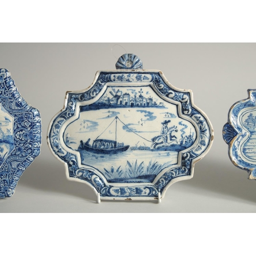 1125 - THREE 19TH CENTURY DUTCH BLUE AND WHITE SHAPED PLAQUES, a horse and rider pulling a barge, Boar Hunt... 