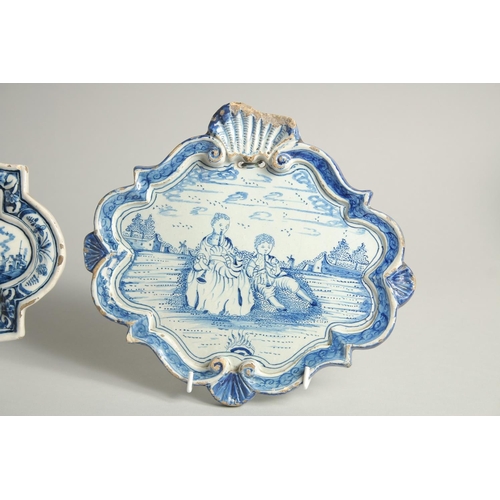 1125 - THREE 19TH CENTURY DUTCH BLUE AND WHITE SHAPED PLAQUES, a horse and rider pulling a barge, Boar Hunt... 