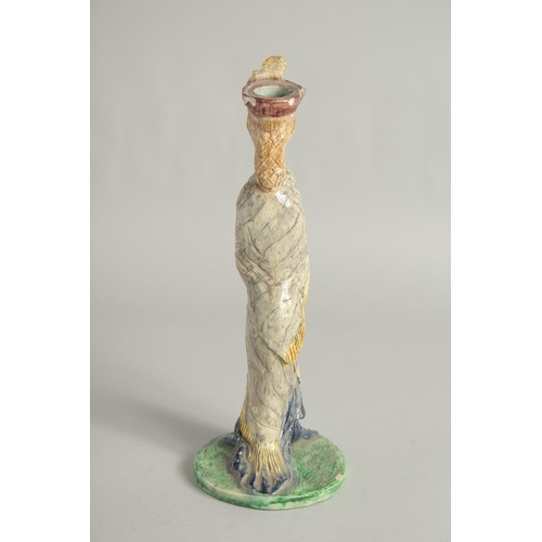 1193 - A MAJOLICA POTTERY CANDLESTICK FIGURE. 11ins high.