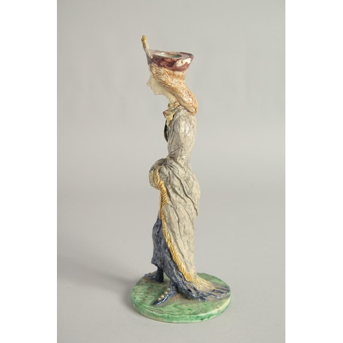 1193 - A MAJOLICA POTTERY CANDLESTICK FIGURE. 11ins high.