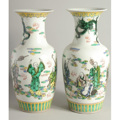 1217 - A PAIR OF CHINESE PORCELAIN VASES painted with people. 1ft 5ins high.