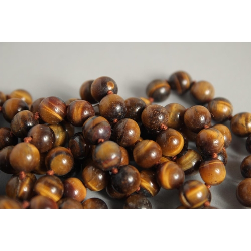 1227 - A STRING OF TIGER'S EYE BEADS. 50ins long.