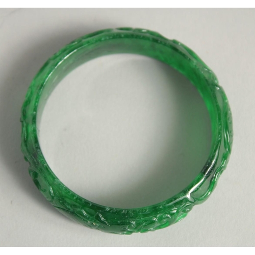 1231 - A CARVED JADE BANGLE. 2.25ins diameter.