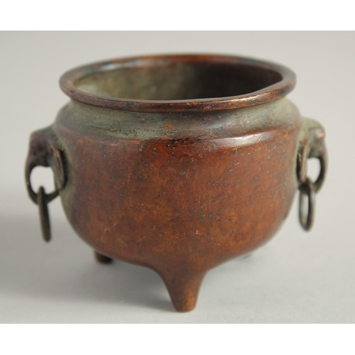 1240 - A SMALL CHINESE BRONZE CIRCULAR CENSER with elephant handles. 2.25ins diameter.