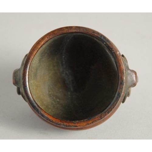 1240 - A SMALL CHINESE BRONZE CIRCULAR CENSER with elephant handles. 2.25ins diameter.