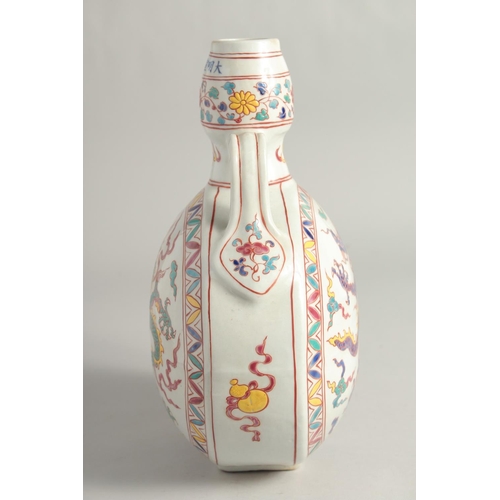 1253 - A CHINESE WUCAI PORCELAIN TWIN HANDLED MOON FLASK decorated with a central dragon. 29cm high.