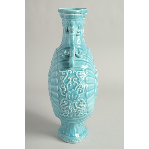 1256 - A CHINESE BLUE GLAZE TWIN HANDLED MOON FLASK with a central relief dragon motif. 33cm high.