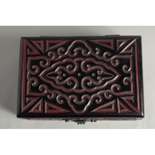 1259 - A CHINESE LACQUERED WOOD RECTANGULAR BOX with carved decoration and hinged lid. 21cm x 14cm