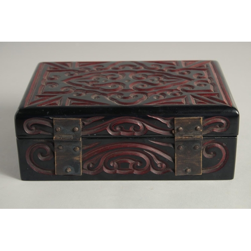 1259 - A CHINESE LACQUERED WOOD RECTANGULAR BOX with carved decoration and hinged lid. 21cm x 14cm