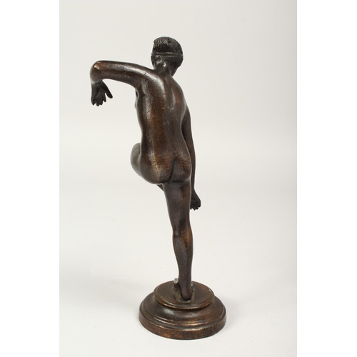 1290 - A 19TH CENTURY BRONZE STANDING NUDE on a circular base. 10ins high.