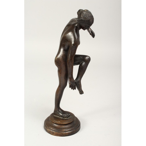 1290 - A 19TH CENTURY BRONZE STANDING NUDE on a circular base. 10ins high.