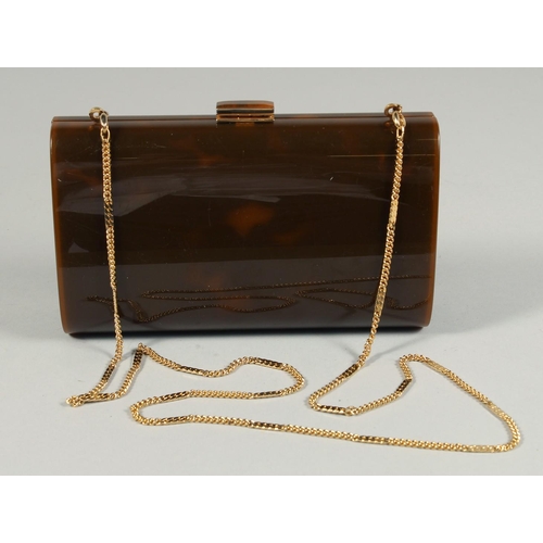 1327 - A FAUX TORTOISESHELL EVENING PURSE with long gilt chain. 7ins long.