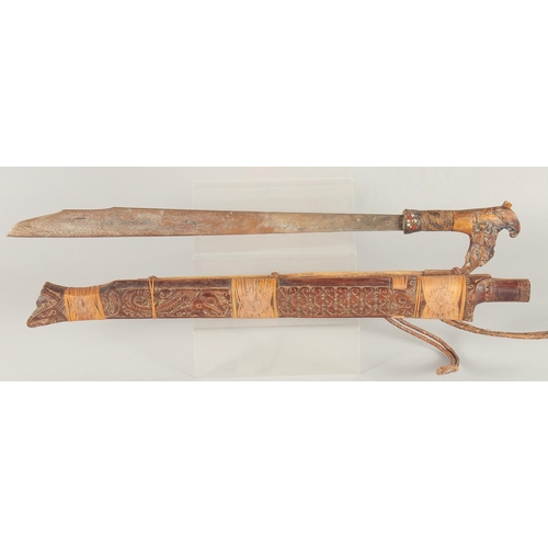 1342 - A BONE HANDLED KRIS SWORD in a wooden sheath. 2ft 4ins long.