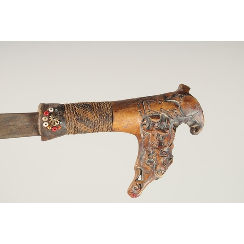 1342 - A BONE HANDLED KRIS SWORD in a wooden sheath. 2ft 4ins long.