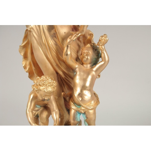 1391 - A GOOD GILT METAL GROUP OF A CLASSICAL YOUNG LADY and two cupids, on a circular marble base. Signed.... 