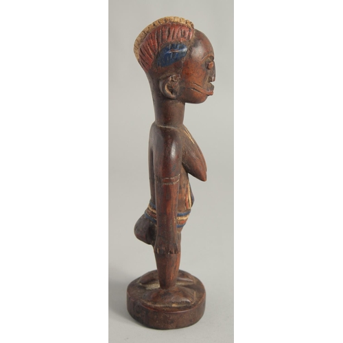 1396 - A CARED WOOD TRIBAL FEMALE FIGURE with old pigment. 10.5ins high.