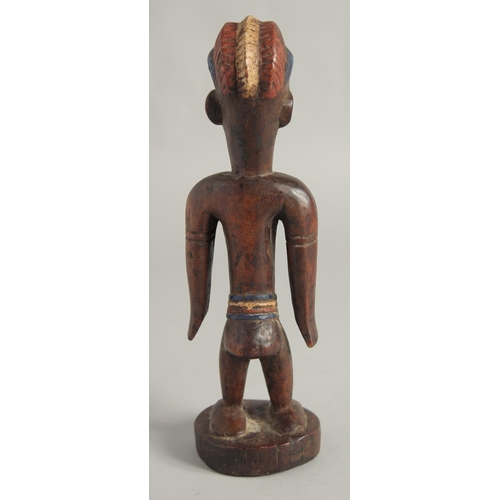 1396 - A CARED WOOD TRIBAL FEMALE FIGURE with old pigment. 10.5ins high.