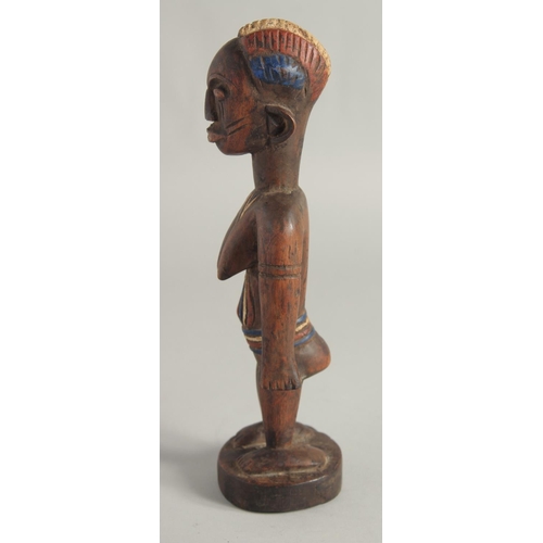 1396 - A CARED WOOD TRIBAL FEMALE FIGURE with old pigment. 10.5ins high.