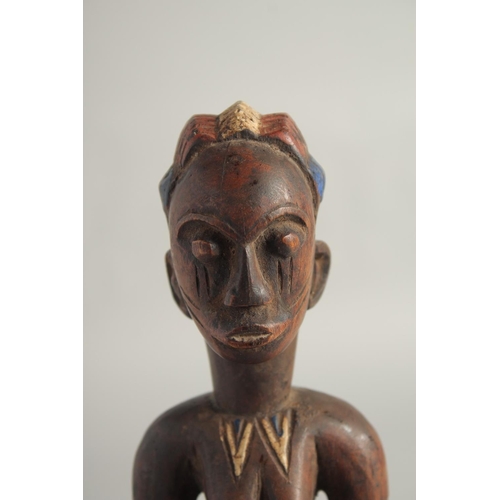 1396 - A CARED WOOD TRIBAL FEMALE FIGURE with old pigment. 10.5ins high.