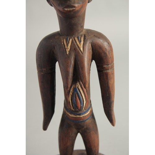 1396 - A CARED WOOD TRIBAL FEMALE FIGURE with old pigment. 10.5ins high.