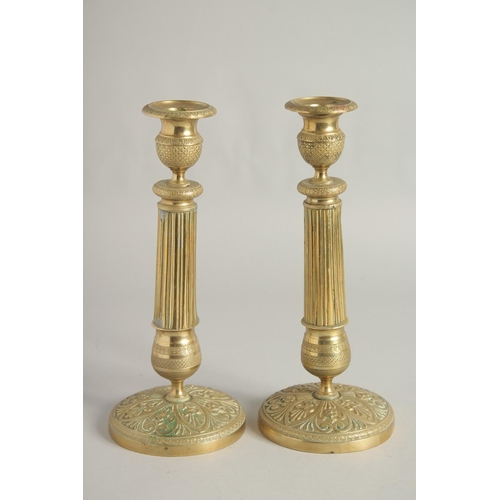 1413 - A PAIR OF EMPIRE ORNATE CANDLESTICKS on circular bases. 11ins high.