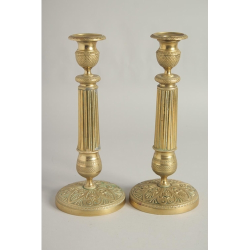 1413 - A PAIR OF EMPIRE ORNATE CANDLESTICKS on circular bases. 11ins high.