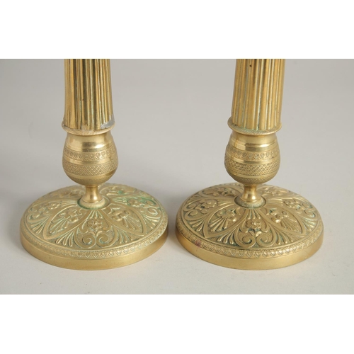 1413 - A PAIR OF EMPIRE ORNATE CANDLESTICKS on circular bases. 11ins high.