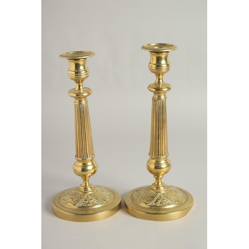 1414 - A PAIR OF EMPIRE ORNATE CANDLESTICKS on circular bases. 11ins high.