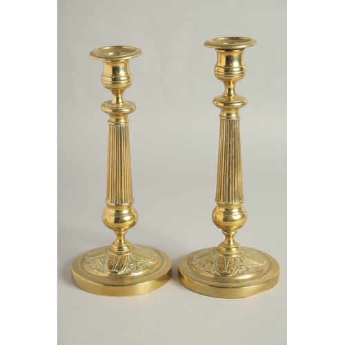 1414 - A PAIR OF EMPIRE ORNATE CANDLESTICKS on circular bases. 11ins high.