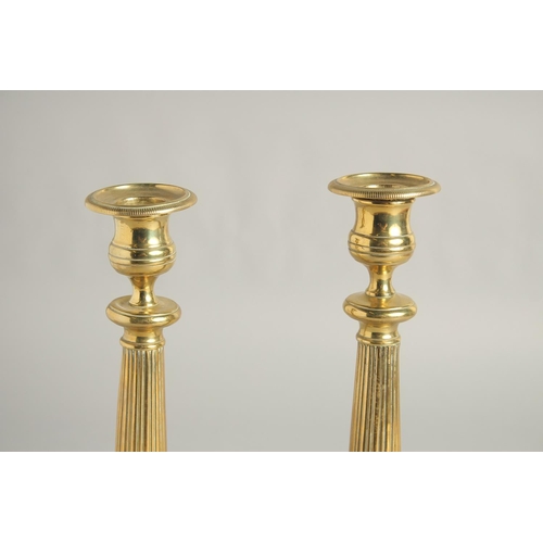 1414 - A PAIR OF EMPIRE ORNATE CANDLESTICKS on circular bases. 11ins high.