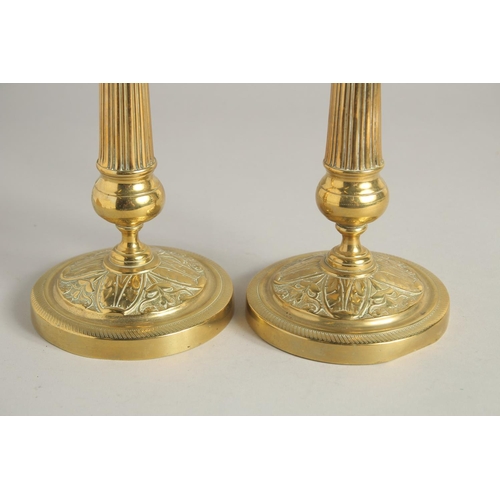 1414 - A PAIR OF EMPIRE ORNATE CANDLESTICKS on circular bases. 11ins high.