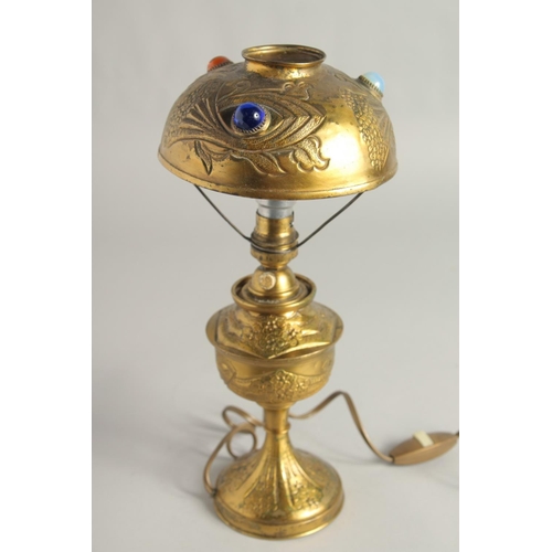 1418 - AN ART DECO GILT METAL LAMP set with three coloured stones. 12.5ins high.