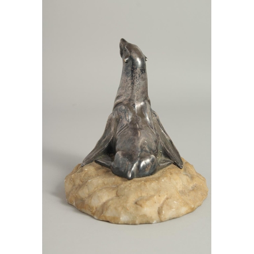 1546 - MOREAUX. A MODEL OF A SEA LION on a stone base. Signed. 5ins long.