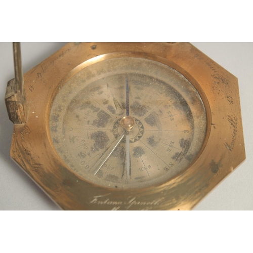 1548 - A GEORGIAN OCTAGONAL BRASS TRAVELLING COMPASS with silvered dial. Made in Paris. 3.75ins in a leathe... 