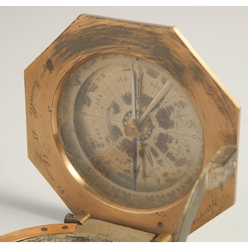 1548 - A GEORGIAN OCTAGONAL BRASS TRAVELLING COMPASS with silvered dial. Made in Paris. 3.75ins in a leathe... 