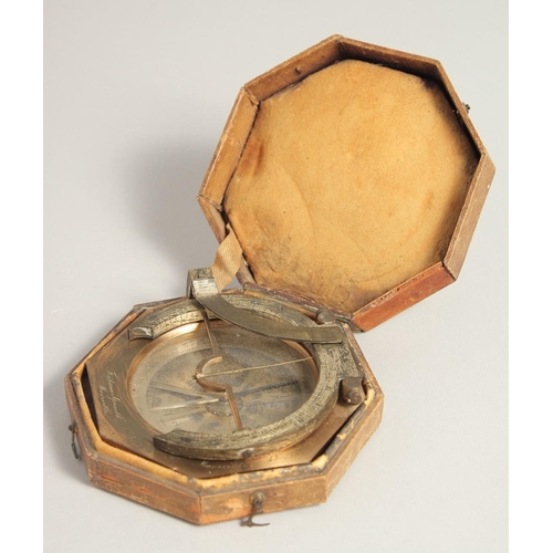 1548 - A GEORGIAN OCTAGONAL BRASS TRAVELLING COMPASS with silvered dial. Made in Paris. 3.75ins in a leathe... 