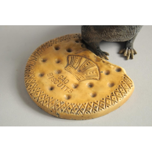 1568 - A COLD CAST MODEL OF A RAT standing beside a biscuit. 4.5ins high.