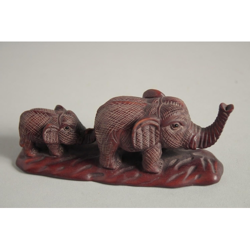 1579 - A JAPANESE CARVED WOOD ELEPHANT AND YOUNG. Signed, 4.5ins long.