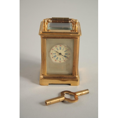 1611 - A MINIATURE GILT FACED CARRIAGE CLOCK. 2ins.