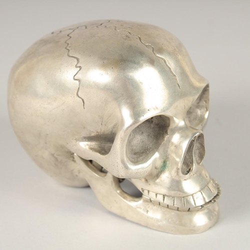 1633 - A SILVER PLATED SKULL with moving jaw. 3ins.