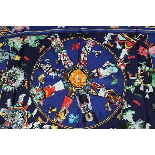 1698 - AN HERMES SILK SCARF, puppet and toy on a blue ground. 34ins x 334ins in a Hermes box.