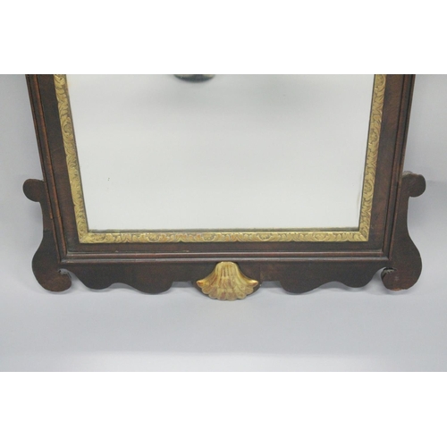 1010 - A GEORGE III MAHOGANY AND GILDED FRETWORK FRAMED WALL MIRROR, with swan neck pediment, curved and gi... 