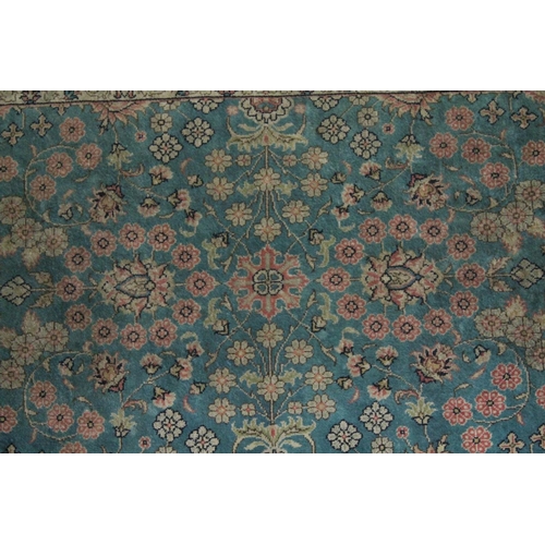 1058 - A GOOD SMALL SHIRVAN SILK RUG turquoise ground with floral decoration in a pink ground border.