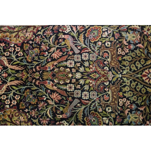 1059 - A GOOD SMALL PERSIAN RUG SHIRVAN OR ISFAHAN, dark blue ground with deer and exotic birds amongst fol... 