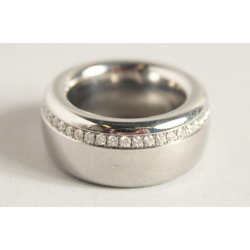 1726 - A DESIGNER TITANIUM RING set with diamonds. 27.8gms.