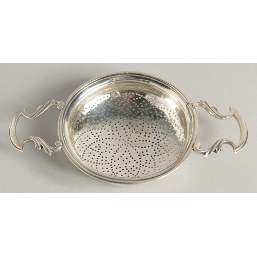 1894 - A GEORGE II SILVER TWO HANDLED CIRCULAR LEMON STRAINER. 3.75ins diameter.  London 1755.  Maker James... 